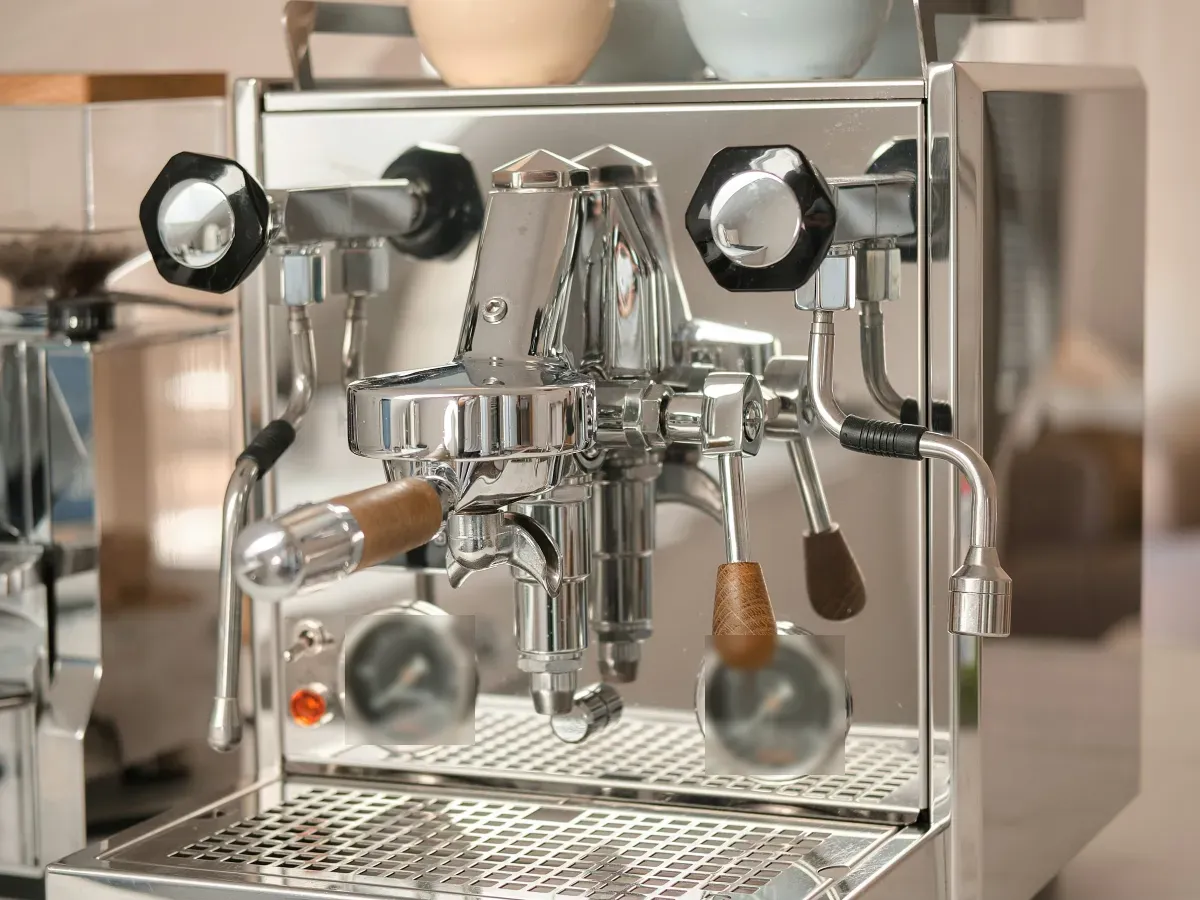 Máy pha espresso bằng inox với tay cầm gỗ trên quầy đá sáng màu